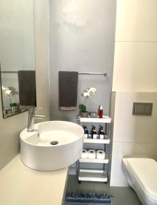 a white bathroom with a sink and a toilet at Stay on Main in Paarl