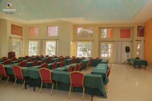 una sala conferenze con tavoli e sedie verdi e finestre di Kabalega Resort - Masindi a Masindi