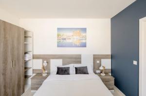 Schlafzimmer mit einem großen weißen Bett und blauen Wänden in der Unterkunft Hammock Vibes Town House in Sliema