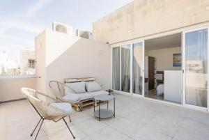 a living room with a couch and a table at Hammock Vibes Town House in Sliema