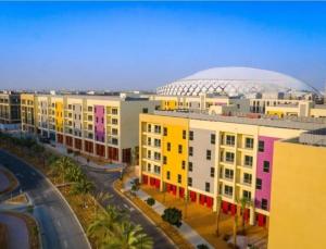 eine Gruppe von Gebäuden mit einer Fußballkuppel im Hintergrund in der Unterkunft New fully serviced 2BR apartment in al-Ain