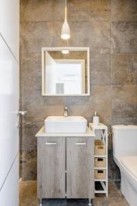 y baño con lavabo y espejo. en Hammock Vibes Town House en Sliema
