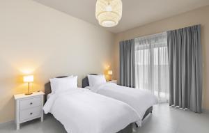 2 weiße Betten in einem Zimmer mit Fenster in der Unterkunft New fully serviced 2BR apartment in al-Ain