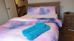 a bed with a blue blanket on top of it at Clayton Living Town House at Monash Doorstep in Clayton North