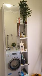 a laundry room with a washing machine in a shelf at Clayton Living Town House at Monash Doorstep in Clayton North +35 photos