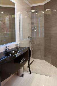 y baño con lavabo negro y ducha. en Hotel Capitulum, en Győr