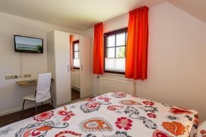 Schlafzimmer mit einem Bett, einem Schreibtisch und einem TV in der Unterkunft Selliner Ferienappartements mit Balkon und Seeblick in Ostseebad Sellin