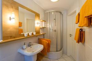 ein Bad mit einem Waschbecken und einer Dusche in der Unterkunft Selliner Ferienappartements mit Balkon und Seeblick in Ostseebad Sellin