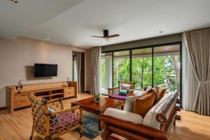 ein Wohnzimmer mit einem Sofa und einem Tisch in der Unterkunft Noku Phuket in Chalong 