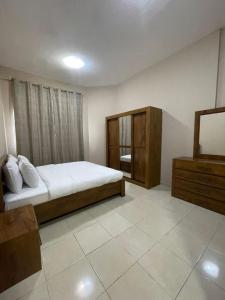 a bedroom with a bed and a dresser in it at Marbella Grand Holiday Homes - Al Nahda 1 in Dubai