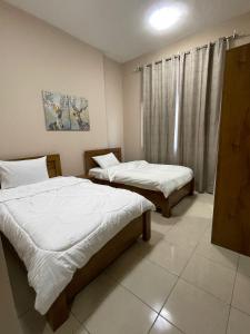 a bedroom with two beds and a window at Marbella Grand Holiday Homes - Al Nahda 1 in Dubai