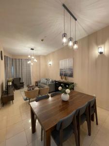 sala de estar con mesa y sofá en Marbella Grand Holiday Homes - Al Nahda 1, en Dubái