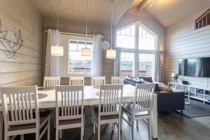 a dining room with a table and chairs and a couch at Villa Peso1 - 9 henkilölle, HimosYkkösen alue in Jämsä +17 photos