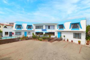 a large white building with a blue roof at Mermaid Guest House in Struisbaai