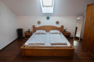 Schlafzimmer mit einem Holzbett und einem Spiegel in der Unterkunft Hanu Fain in Reşiţa