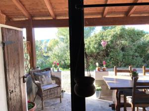 an open door to a patio with a table and chairs at ROBY’s NEST in Maracalagonis