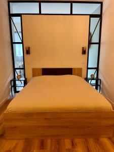 uma cama num quarto com uma grande janela em F2 Au cœur des volcans d’Auvergne em Royat