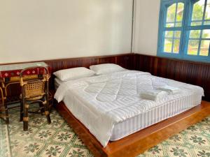 a bedroom with a large bed and a chair at B2 Hotel Savannakhet in Savannakhet