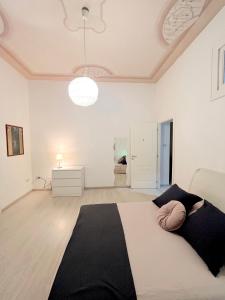 a bedroom with a large bed in a white room at Deodato Guest House in Catania