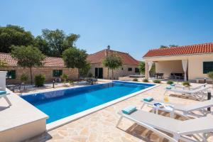 a swimming pool with two chairs and a house at Tosic Estate - Villa, Vineyards and Winery in Razvođe