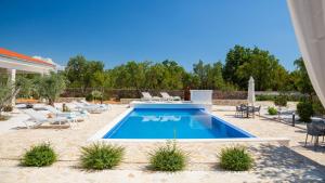 a swimming pool in a yard with chairs at Tosic Estate - Villa, Vineyards and Winery in Razvođe