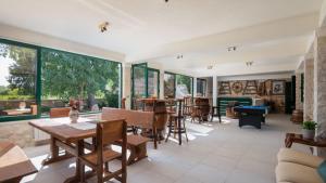a living room with a table and chairs and windows at Tosic Estate - Villa, Vineyards and Winery in Razvođe