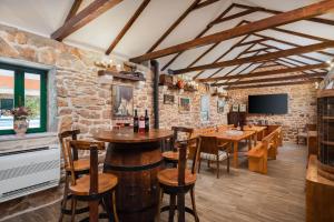 a bar with wooden tables and chairs and a stone wall at Tosic Estate - Villa, Vineyards and Winery in Razvođe