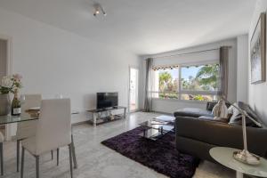 un soggiorno con divano e tavolo di First Line Apartment in Puerto Banus a Marbella