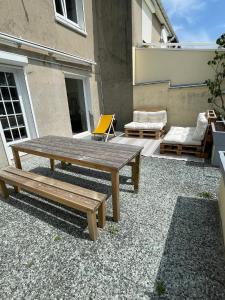 patio con tavolo in legno e panca di Maison 2 chambres Cavaignac a Calais
