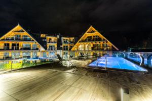 a large building with a swimming pool at night at Apartamenty Royal Resort Spa in Zakopane