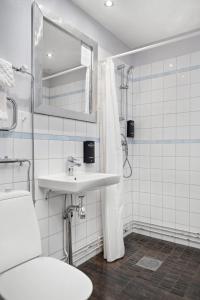 a white bathroom with a sink and a mirror at Stadsparken Apartments in Helsingborg