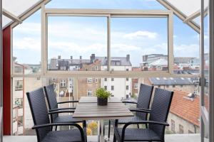 einen Tisch und Stühle vor einem großen Fenster in der Unterkunft Stadsparken Apartments in Helsingborg
