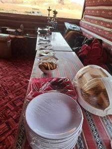 een lange tafel met borden en kommen met eten erop bij Wadi Rum Desert Heart in Wadi Rum