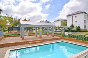 una piscina con cenador y un edificio en New Apartment, en Chartwell