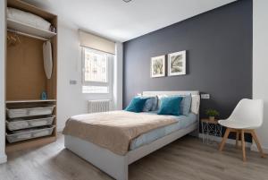 a bedroom with a bed with blue pillows at Apartamento Manola con terraza junto al Corte Inglés in Albacete