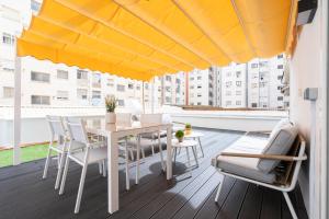 balcone con tavolo, sedie e ombrellone giallo di Apartamento Manola con terraza junto al Corte Inglés ad Albacete
