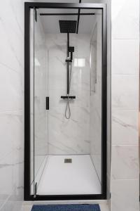 y baño con ducha y puerta de cristal. en Apartamento Manola con terraza junto al Corte Inglés, en Albacete