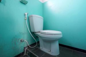 a bathroom with a toilet in a blue wall at OYO 93248 Villa Syariah Astuti Lestari in Bandung