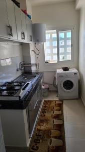 a kitchen with a stove and a washing machine at Appartement al hoceima pour les familles in Al Hoceïma