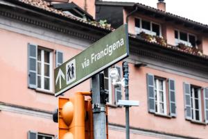 a street sign on a traffic light in front of a building at ANGOLO AL PONTE micro appartamento in pieno centro in Pavia