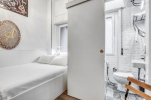 a white bathroom with a bed and a toilet at ANGOLO AL PONTE micro appartamento in pieno centro in Pavia