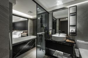 een badkamer met een wastafel, een douche en een bad bij Autumn Willow Hotel in Taichung +183 foto's