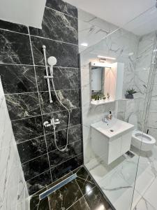 ein Bad mit einer schwarz-weißen Marmorwand in der Unterkunft Corner penthouse apartment in the centar of Skopje in Skopje