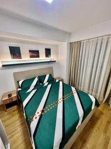 ein Schlafzimmer mit einem grünen und weißen Bett und einem Fenster in der Unterkunft Corner penthouse apartment in the centar of Skopje in Skopje