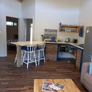 a kitchen with a table and chairs in a room at Brand new cottage, walk to beach - inverter, wi-fi, DSTV in Cape St Francis