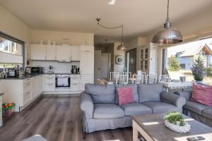 a living room and kitchen with a couch and a table at Ostsee - Reetdachhaus Nr 42 "Waterkant" im Strand Resort in Heiligenhafen