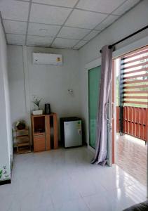 uma sala de estar com uma janela e uma televisão em Bankhu Homestay บ้านคู่โฮมสเตย์ em Suan Phung