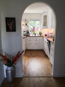 a kitchen with white cabinets and a vase with flowers at Coolt Oxie in Oxie