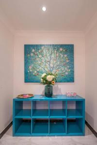 un cabinet bleu avec un vase de fleurs sur lui dans l'établissement Luxury Living 2 Bedrooms 4 Beds 2B athrooms in Southern Brisbane+ Parking, à Brisbane