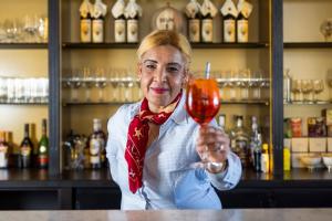 kobieta trzymająca kieliszek wina w barze w obiekcie Hotel Villa Select w mieście De Panne